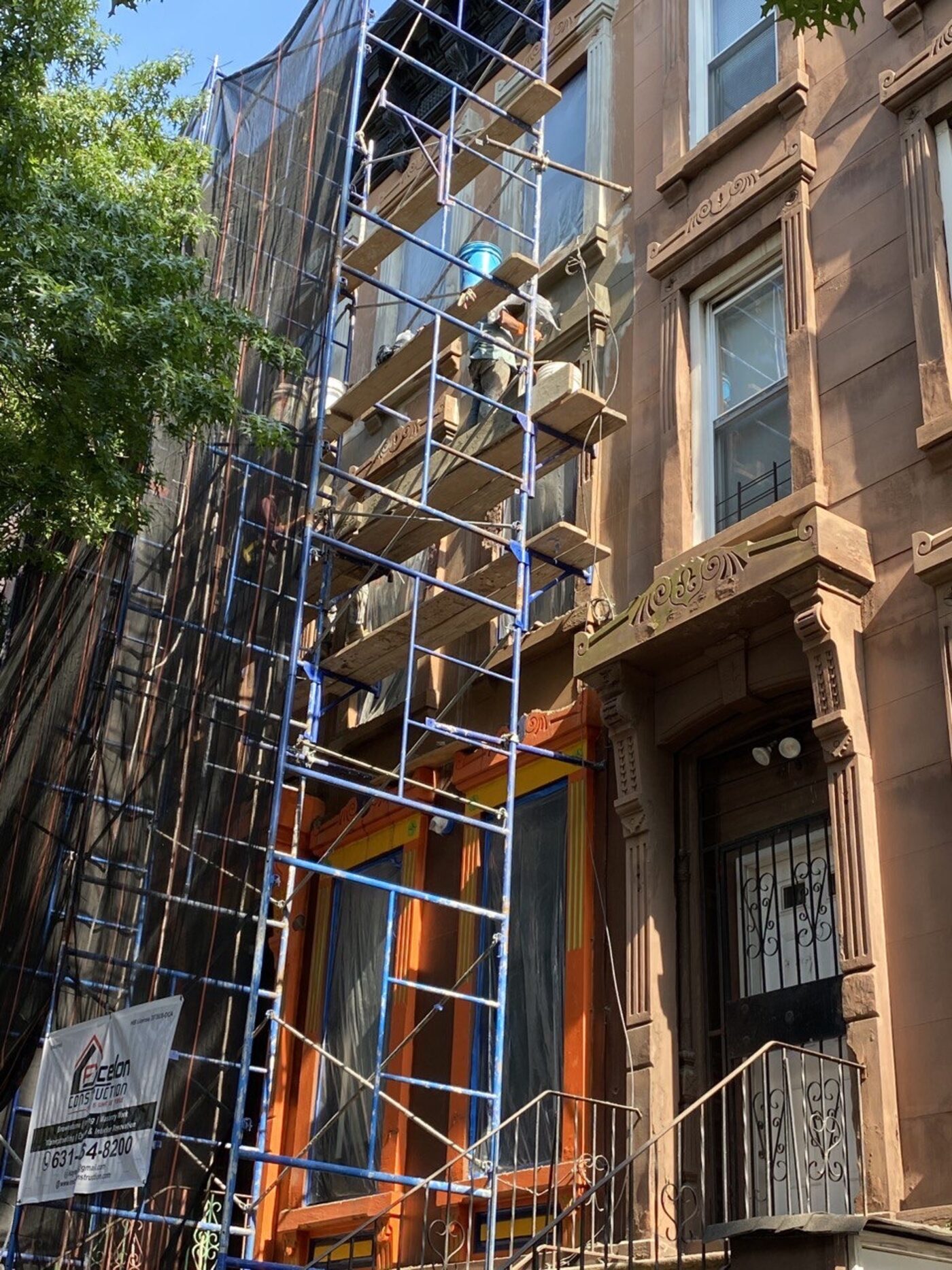 Park Slope brownstone restoration project in progress, showing the careful color-matching of new stone to the existing facade